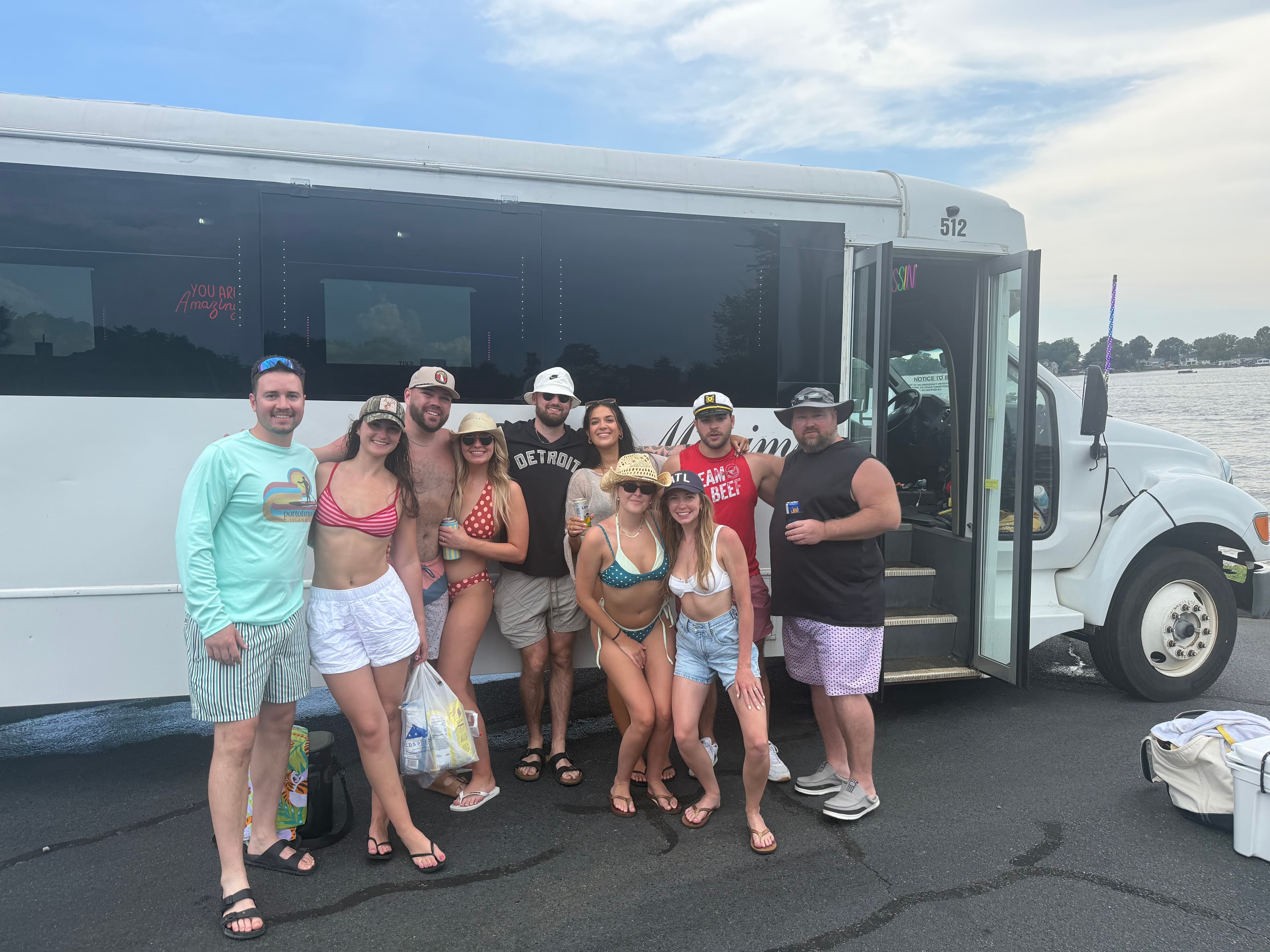 Group boarding a Prestige party bus at the Lake Norman waterfront for a party boat day