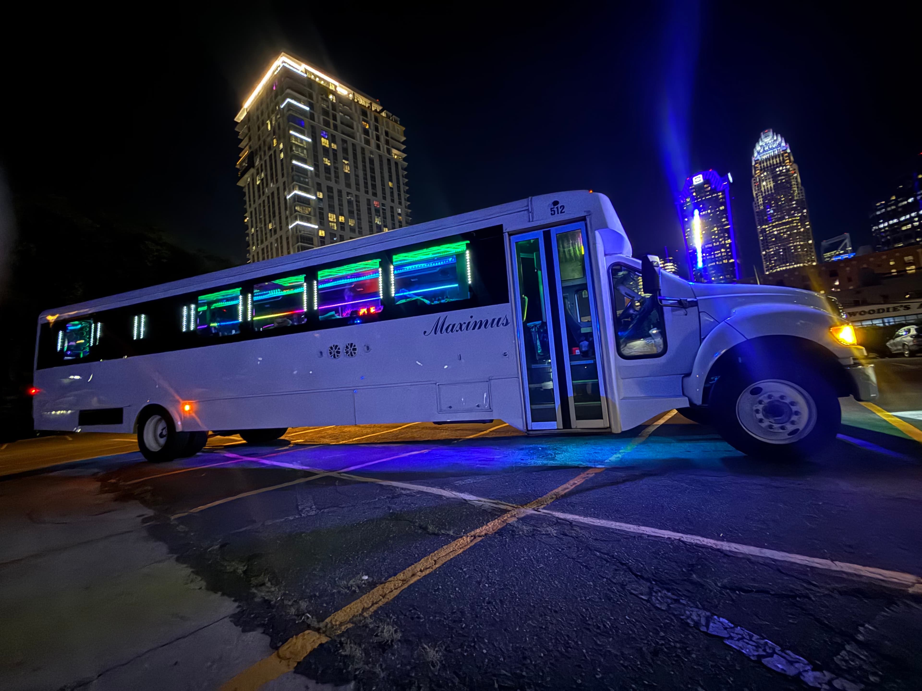 MAXIMUS 40 passenger party bus at night with RGB-lit windows and Charlotte skyline