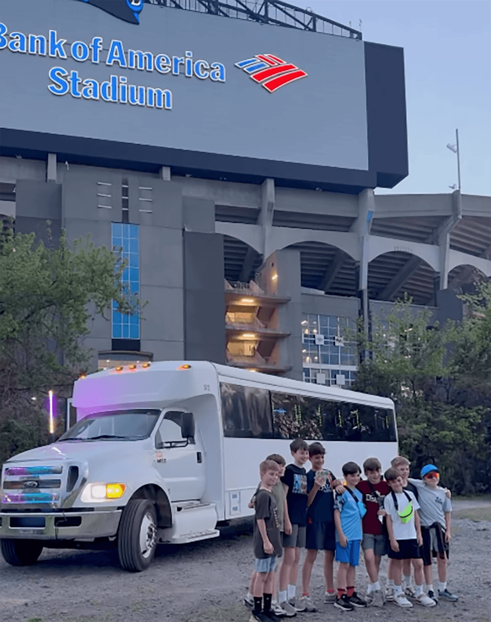 Tailgate party outside the stadium with fans, game-day setup, and luxury transportation